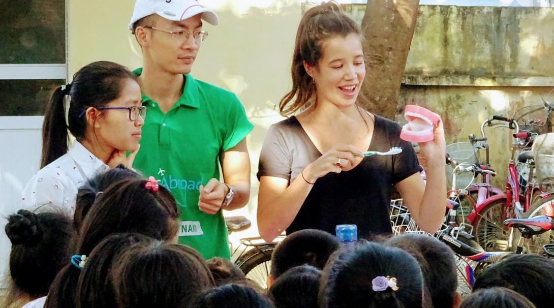 Projects Abroad volunteer working with children in Vietnam demonstrates how to brush your teeth at a Childcare placement. A group of Childcare volunteers teach a group of children how to brush their teeth at a care centre in Vietnam.